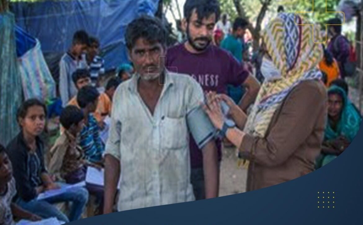 A healthcare worker checks a man's blood pressure at a free health screening camp in a rural area.